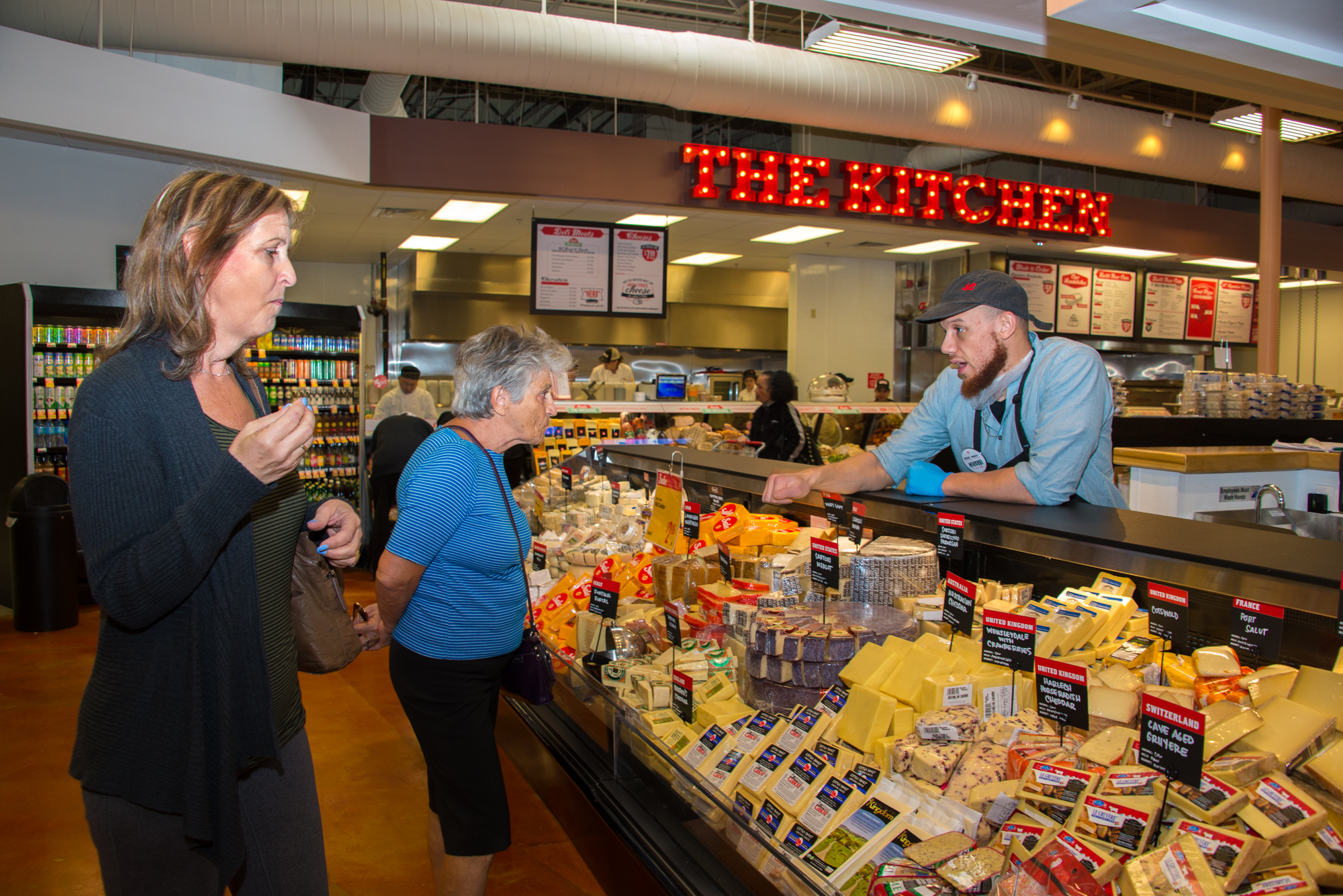 Customers tasting fresh cheese samples at the new Lucky’s Market.