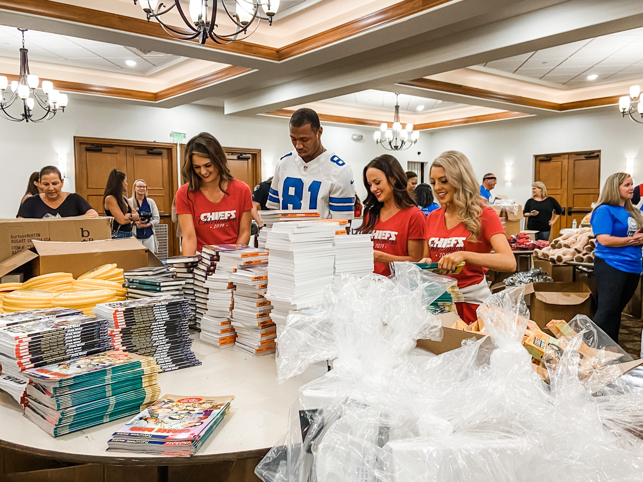 Former NFL Player Laurent Robinson and cheerleaders from the Kansas City Chiefs assemble baskets at Parkland Golf & Country Club. With Super Bowl Cheerleaders